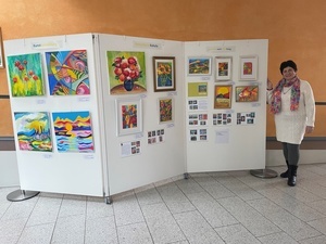 Die Künstlerin Roksoliana Kotula steht im Foyer des neuen Rathauses an einer Stellwand mit ihren Kunstwerken