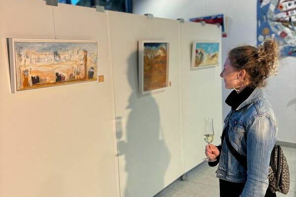 Besucherin bewundert das Bild "Lost in desert", 2024, Acryl auf Leinwand, Elv. A. Struber