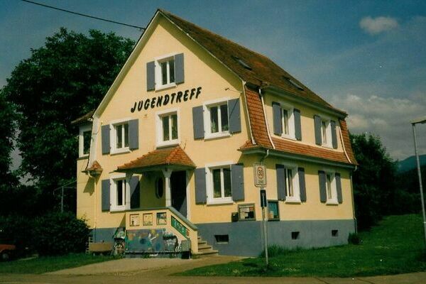 Ein älteres Foto des Jugendtreffs in der Hindenburgstraße.  Für eine detailreiche Bildbeschreibung wählen Sie die Reisekarte Barrierefreiheit und suchen Sie nach der Überschrift Vergilbter Jugendtreff.