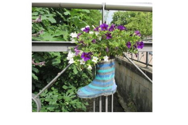 Ein alter Gummistiefel mit eingepflanzten Blumen Ein alter Gummistiefel mit eingepflanzten Blumen