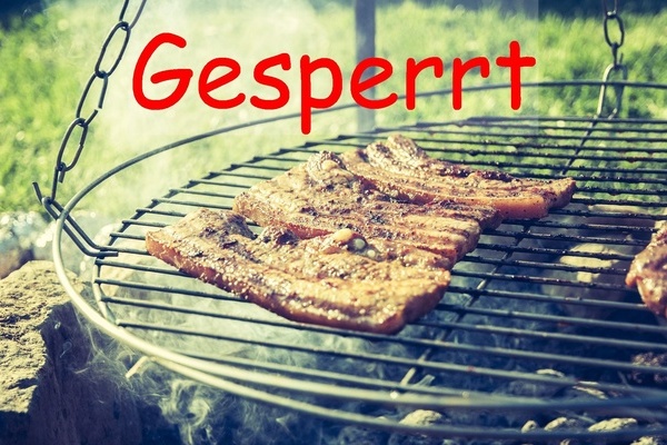 Grillstelle mit aufgelegtem Grillgut und mit dem Hinweis "Gesperrt"