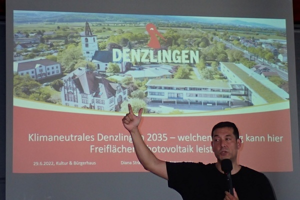 Brgermeister Hollemann zeigt auf eine Leinwand und begrt die Veranstaltung