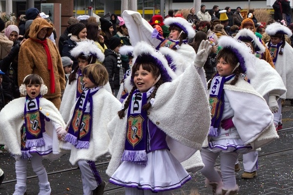 Fastnachtsumzug mit Kindern in weiß/lilanem Garde-Kostüm Fastnachtsumzug mit Kindern in weiß/lilanem Garde-Kostüm