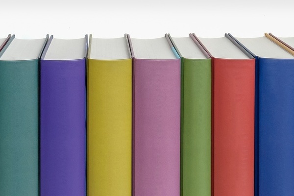 Reihe bunter Buchrücken vor weißem Hintergrund Reihe bunter Buchrücken vor weißem Hintergrund