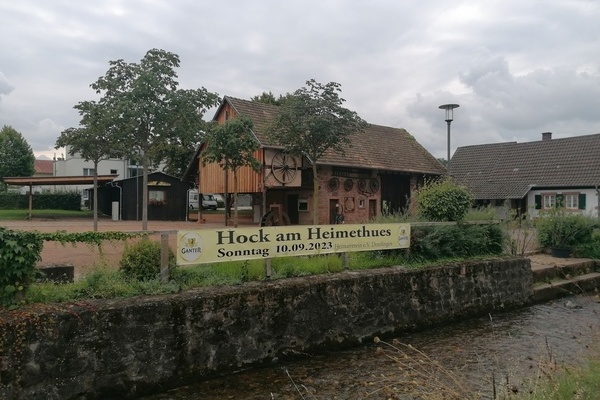 Blick auf den Banner mit der Aufschrift "Hock am Heimethues Sonntag, 10.09.2023", angebracht am Glottergel&auml;nder, im Hintergrund die Museumsscheune