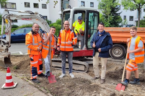 Sechs Männer auf einer Baustelle. Einer der Männer sitzt in einem Bagger Sechs Männer auf einer Baustelle. Einer der Männer sitzt in einem Bagger