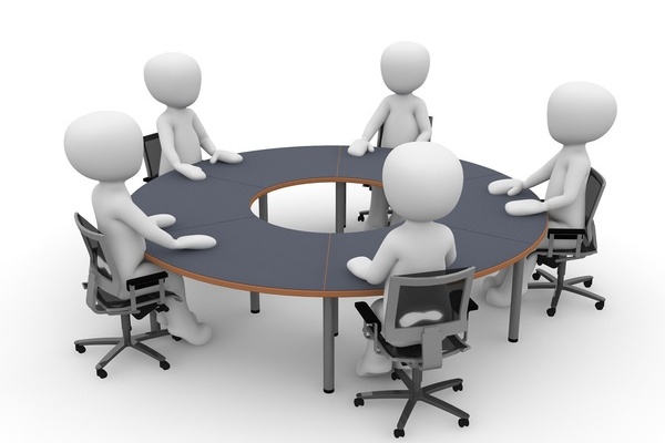 Zeichnung: mehrere Personen sitzen an einem Tisch Zeichnung: mehrere Personen sitzen an einem Tisch