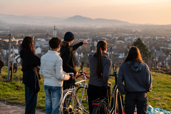 Eine Gruppe Jugendlicher mit Fahrr&auml;dern blicken &uuml;ber die Gemeinde Denzlingen. Foto: Peter Herrmann / Gemeinde Denzlingen