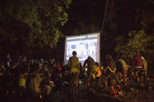 Bild: Das Fahrradkino wird allein durch Muskelkraft angetrieben. Zehn Personen treten in die Pedale um die Energie für Projektor, Laptop und Lautsprecher zu erzeugen. Foto: Verein Solare Zukunft e.V.