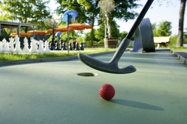Minigolfschläger mit Minigolfball auf einer Minigolfbahn Minigolfschläger mit Minigolfball auf einer Minigolfbahn
